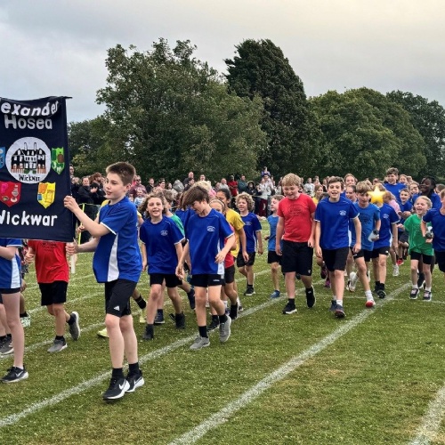 Children parading with banner at district sports event